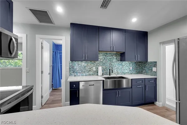 a kitchen with stainless steel appliances granite countertop a refrigerator and a stove top oven