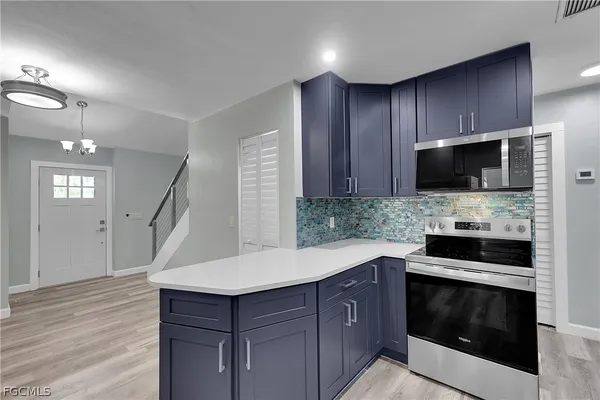 a kitchen with kitchen island granite countertop a stove microwave and wooden floor