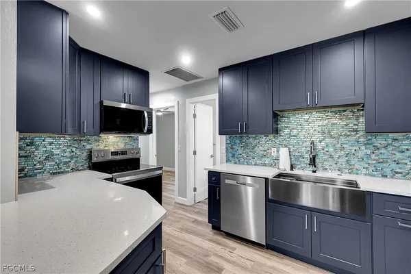 a kitchen with a sink a stove and cabinets