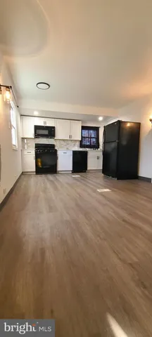 a view of a kitchen with stainless steel appliances wooden floor and a sink