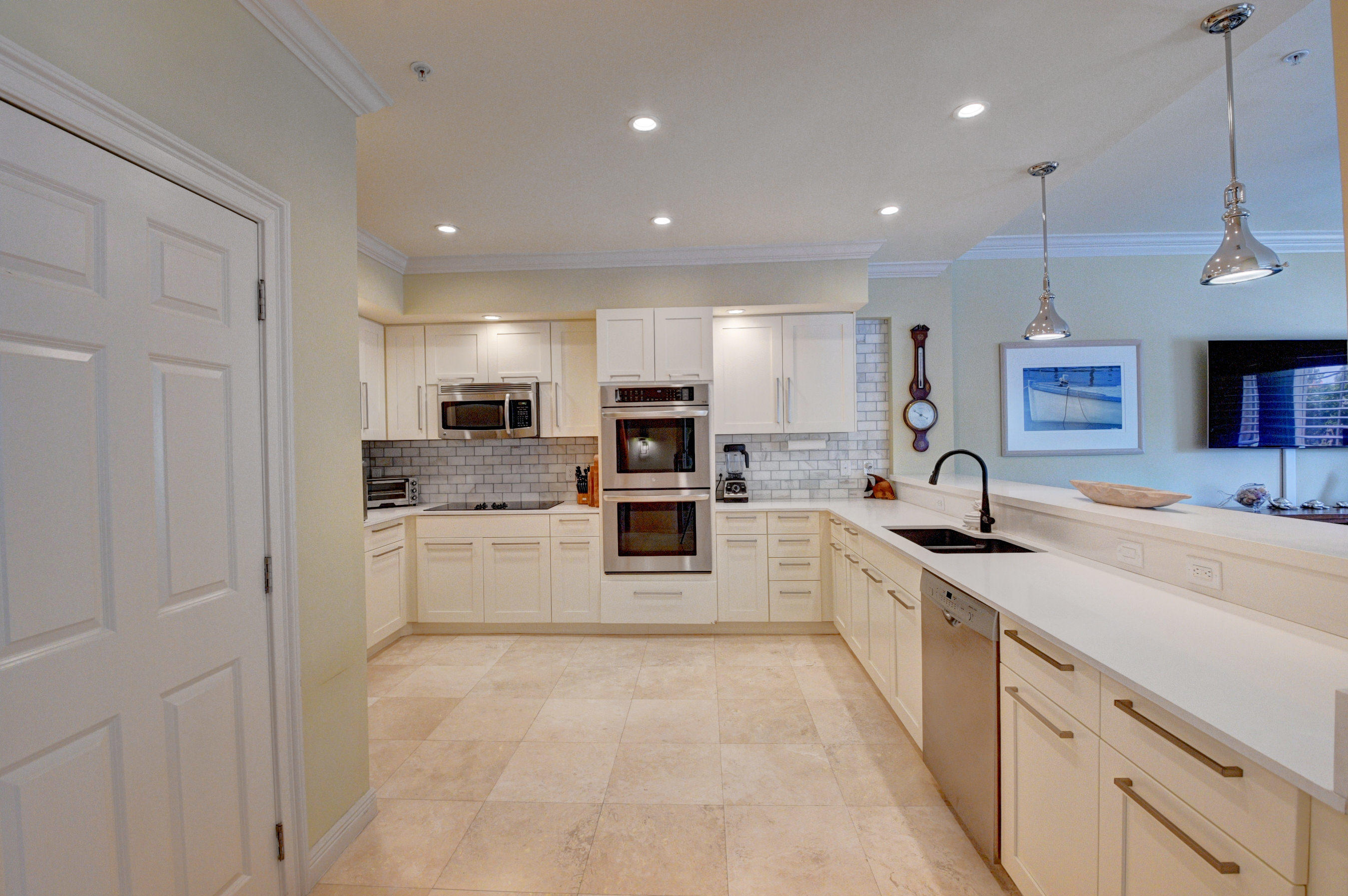 492 East Boca Raton Road Boca Raton, FL 33432 - Photo 17 of 44 a large kitchen with stainless steel appliances lots of white cabinets a sink dishwasher a stove and a refrigerator