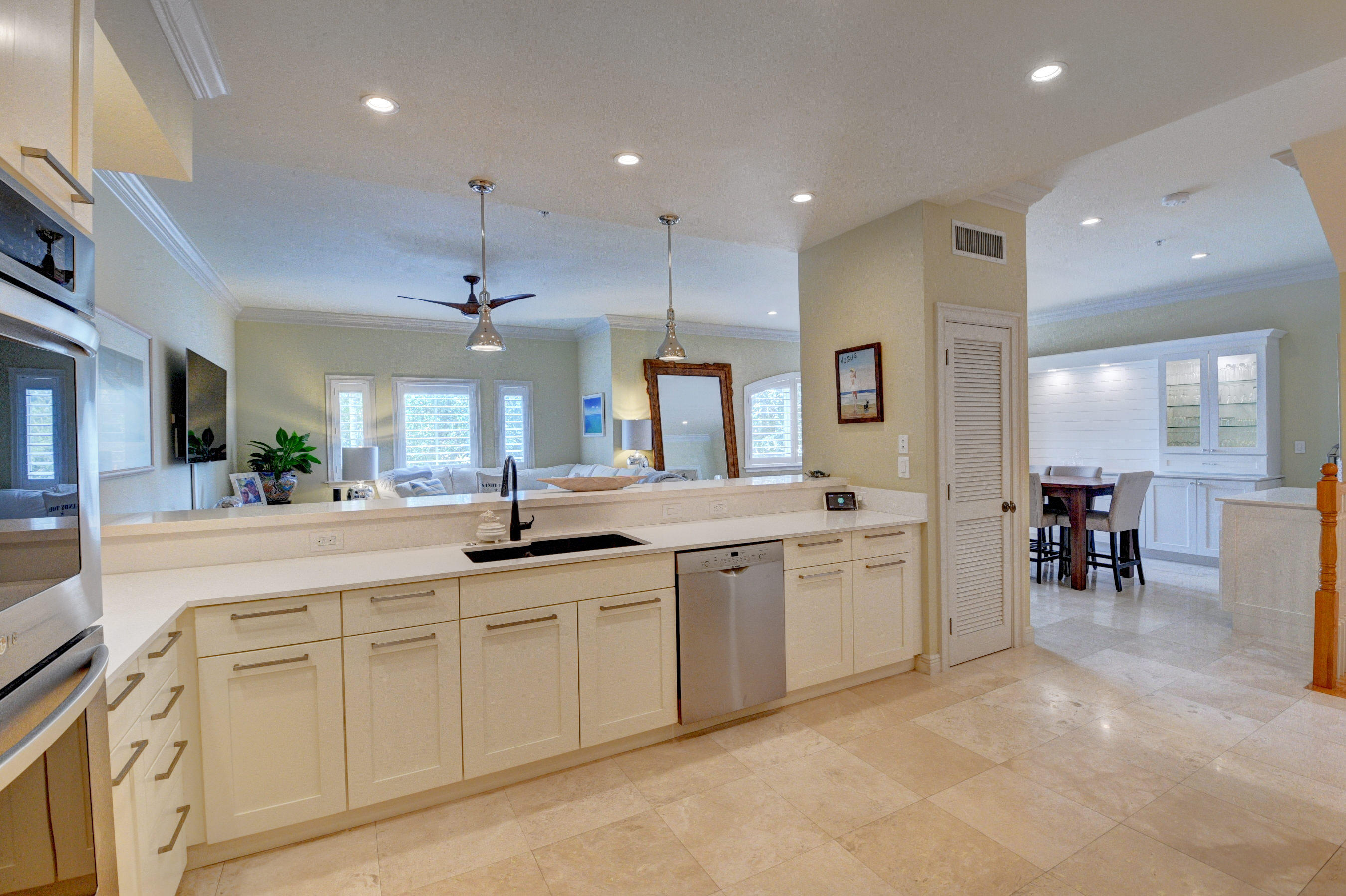 492 East Boca Raton Road Boca Raton, FL 33432 - Photo 20 of 44 a large white kitchen with a large island in the center and stainless steel appliances