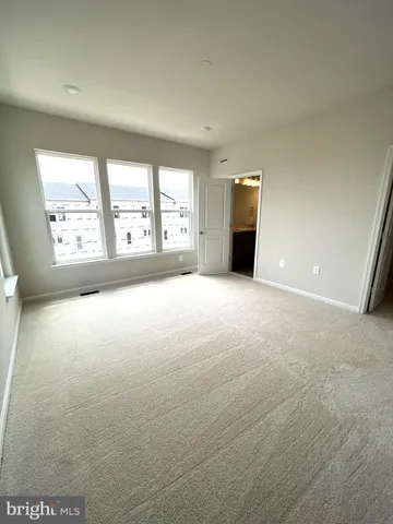 an empty room with windows and fireplace