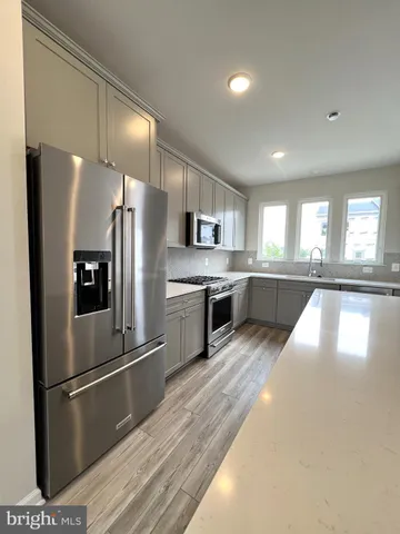 a kitchen with stainless steel appliances granite countertop a refrigerator a stove a sink and a oven