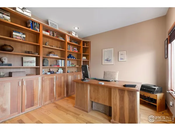 a living room with stainless steel appliances kitchen island granite countertop a refrigerator a sink dishwasher and wooden cabinets with wooden floor