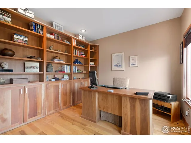 a living room with stainless steel appliances kitchen island granite countertop a refrigerator a sink dishwasher and wooden cabinets with wooden floor