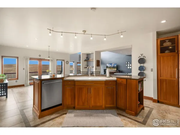 a kitchen with stainless steel appliances granite countertop a sink dishwasher and cabinets with wooden floor
