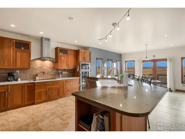 a kitchen with stainless steel appliances kitchen island granite countertop a refrigerator and cabinets
