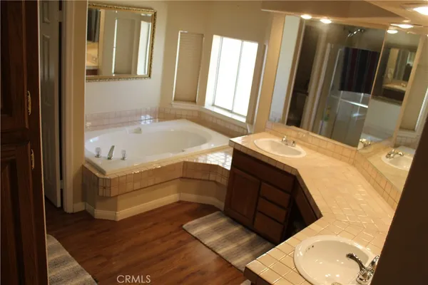 a bathroom with a tub sink and mirror