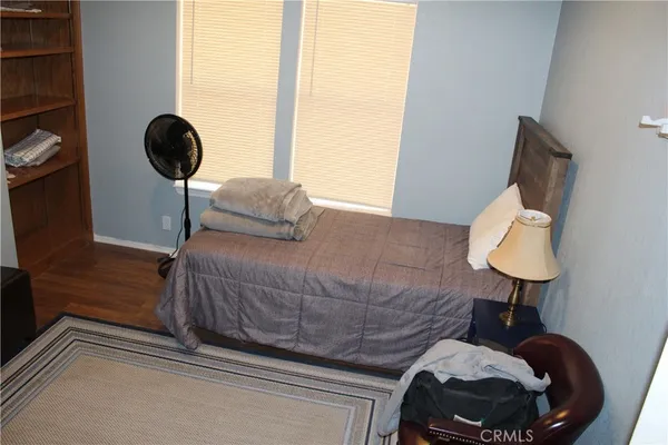 a bedroom with a bed and a lamp next to a large window