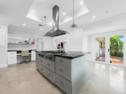 a kitchen with stainless steel appliances a sink a stove and chairs