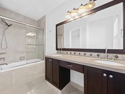 a bathroom with a double vanity sink mirror double and bathtub