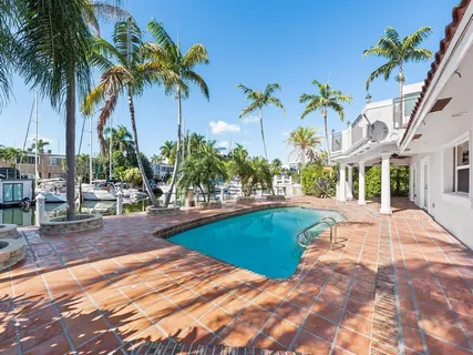 a view of swimming pool with palm trees