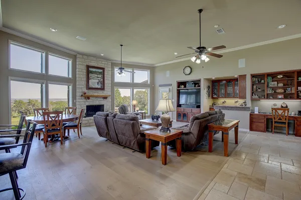 a living room with furniture a fireplace and a floor to ceiling window