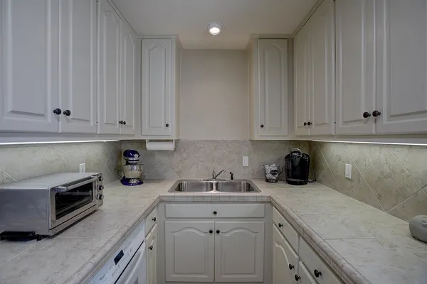a spacious bathroom with a granite countertop sink and a mirror