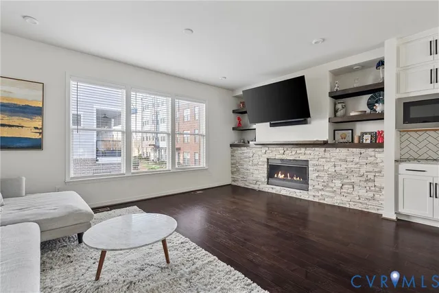 a living room with furniture a flat screen tv and a fireplace