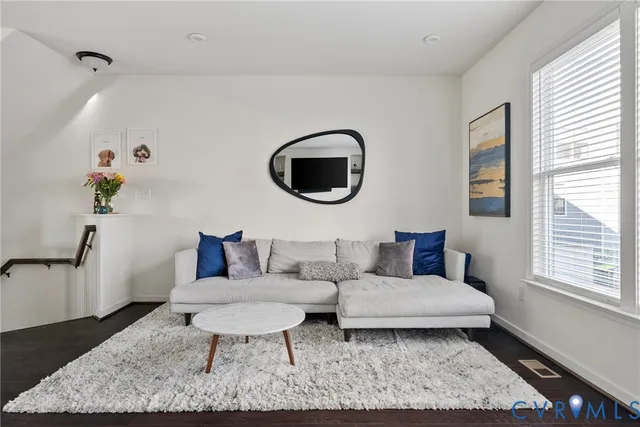 a living room with furniture and a wooden floor