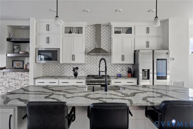 a kitchen with stainless steel appliances granite countertop a sink and a refrigerator