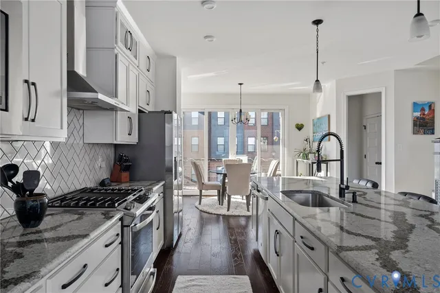 a kitchen with lots of counter top space a sink stainless steel appliances and cabinets