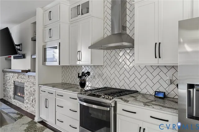 a kitchen with stainless steel appliances granite countertop white cabinets and a stove