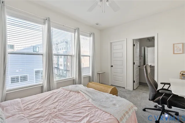 a bathroom with a sink a toilet a window and shower