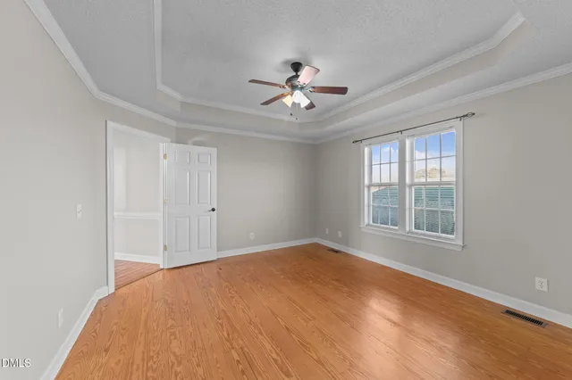 a view of a big room with windows and chandelier fan