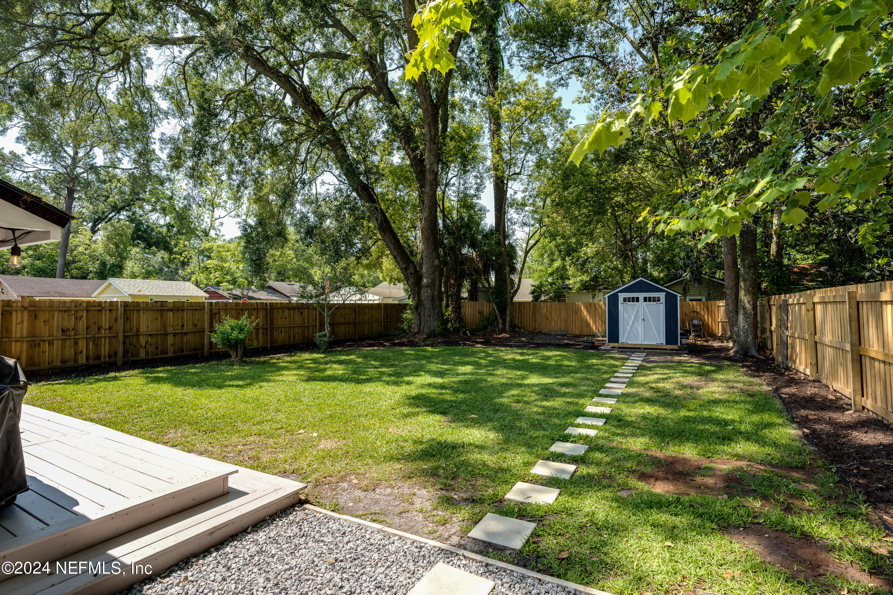 1322 Rensselaer Avenue Jacksonville, FL 32205 - Photo 34 of 37 a view of a backyard with large trees and wooden fence