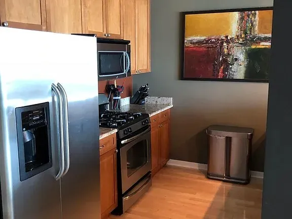 a kitchen with stainless steel appliances granite countertop a refrigerator and a stove top oven