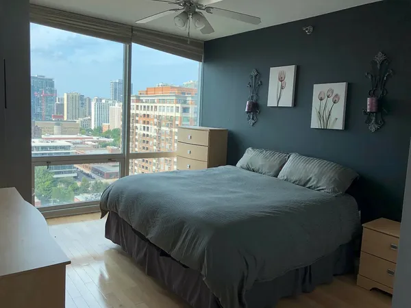 a bedroom with a bed and a large window