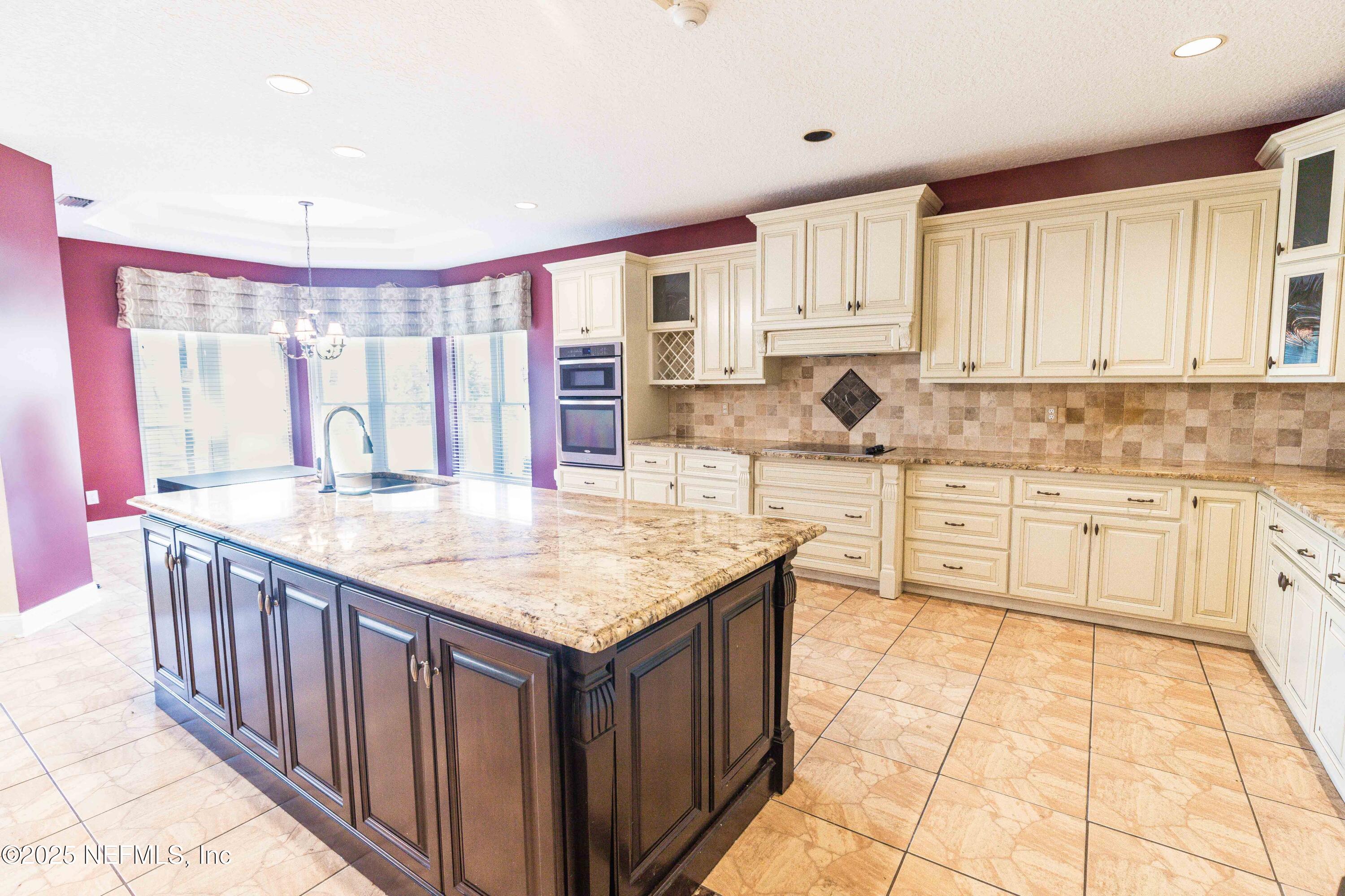 9912 Margate Hills Road Jacksonville, FL 32256 - Photo 5 of 17 a kitchen with stainless steel appliances kitchen island granite countertop a stove a sink and white cabinets