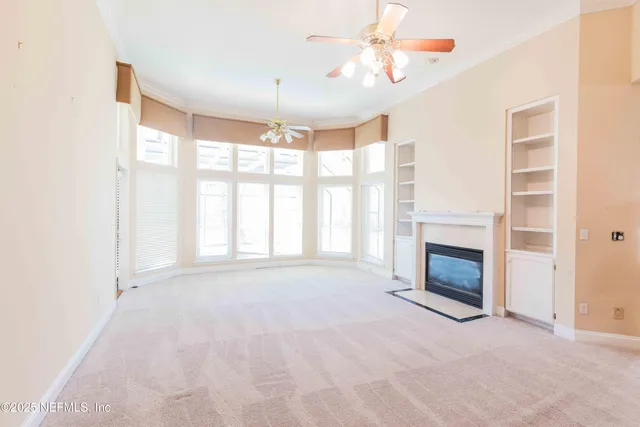 a view of empty room with fireplace and fan