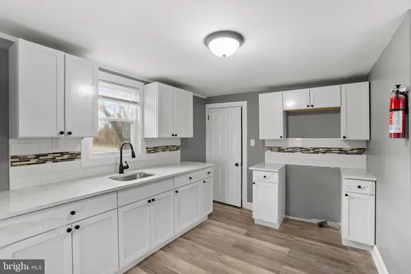 a kitchen with white cabinets and appliances