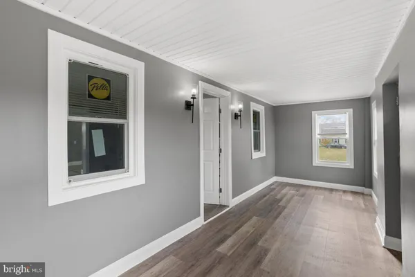 a view of an empty room with window and closet area