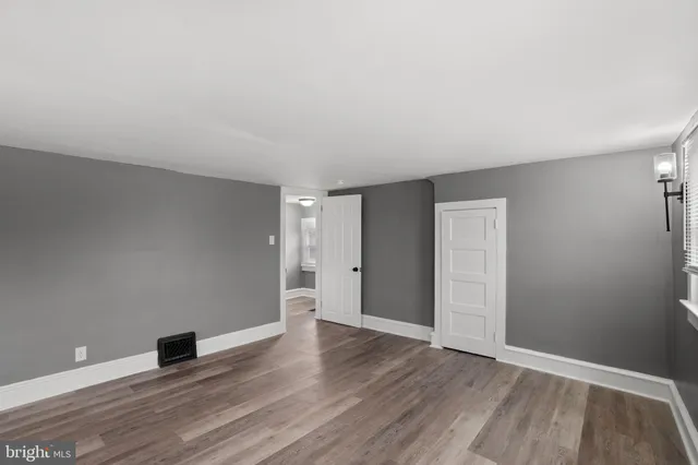 a view of an empty room with wooden floor