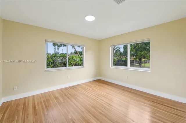 wooden floor in an empty room with a window