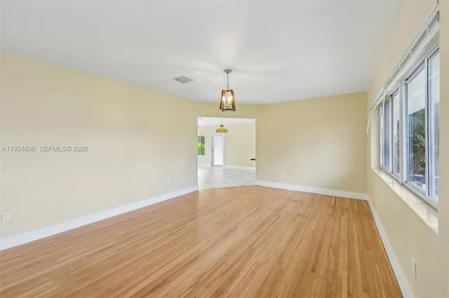 wooden floor in an empty room with a window
