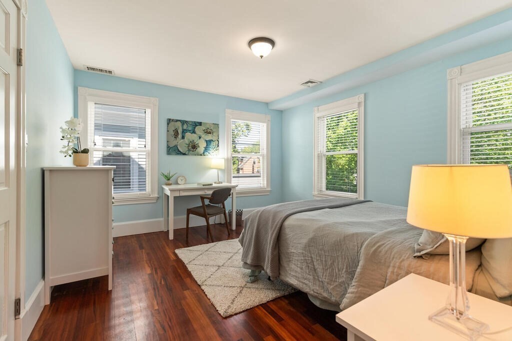 22 Fletcher Street, Unit 22 Winchester, MA 01890 - Photo 14 of 31 a bedroom with a bed and wooden floor