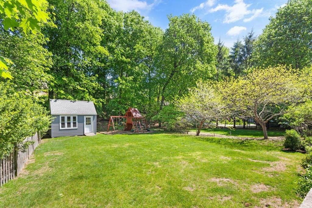 22 Fletcher Street, Unit 22 Winchester, MA 01890 - Photo 26 of 31 a backyard of a house with lawn chairs and a large tree