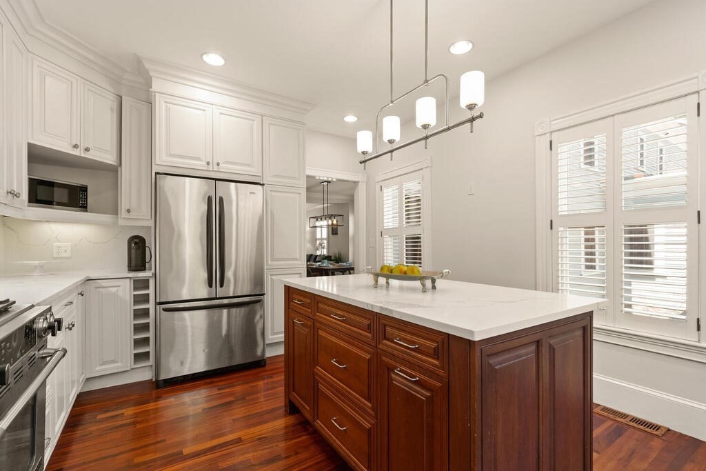 22 Fletcher Street, Unit 22 Winchester, MA 01890 - Photo 8 of 31 a kitchen with a refrigerator a sink and wooden floor