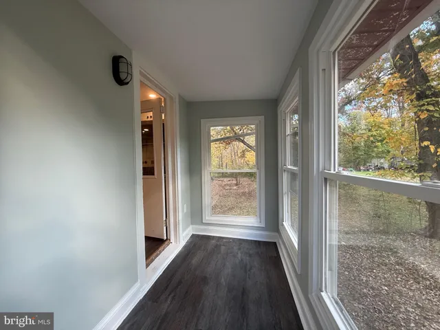 a view of a hallway with wooden floor and a window