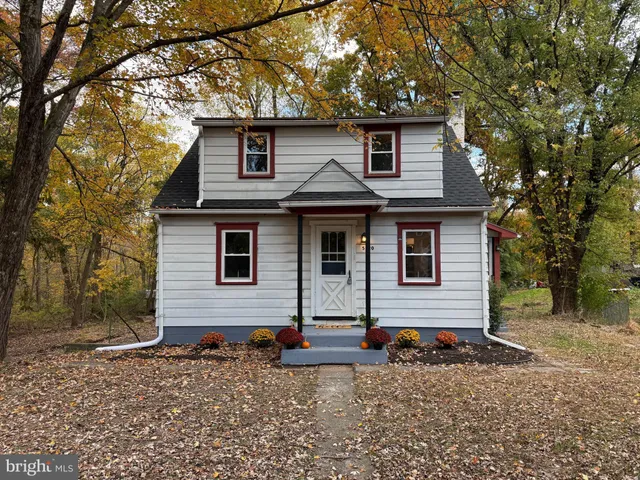a view of a house with a yard and large tree