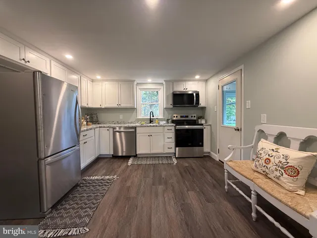 a kitchen with stainless steel appliances a refrigerator sink and microwave