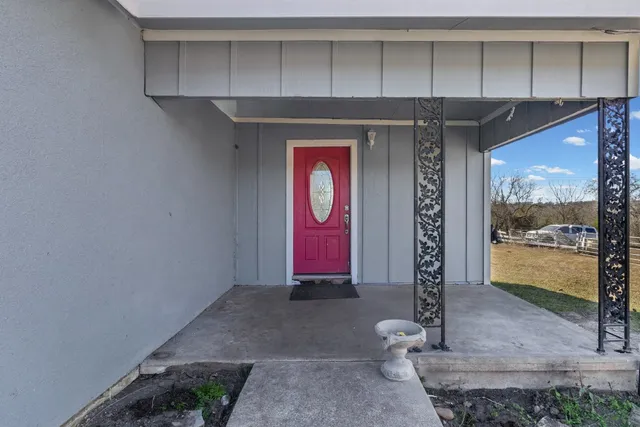 an empty room with wooden floor fireplace and windows