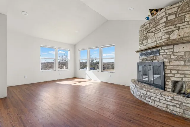 an empty room with wooden floor and fireplace