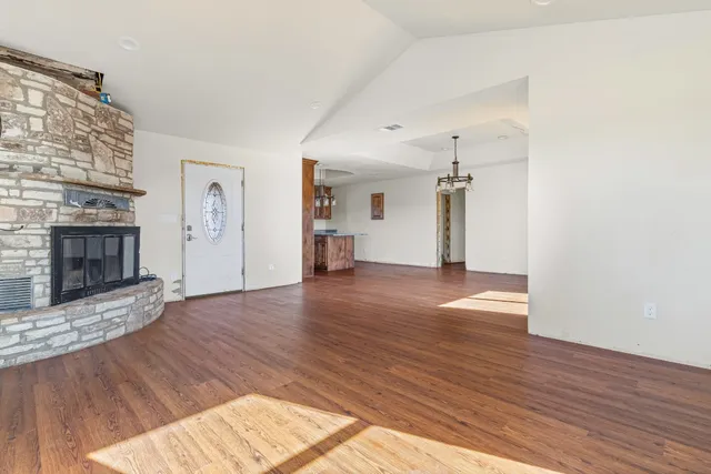 a view of a livingroom with wooden floor and a fireplace