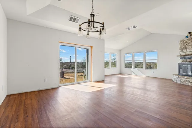 a kitchen with stainless steel appliances granite countertop a sink a stove a refrigerator cabinets and wooden floor