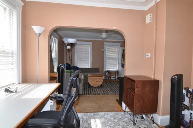 a view of a hallway with chairs and wooden floor