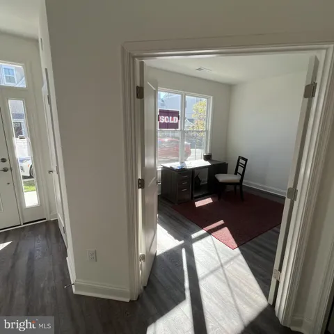 a view of a hallway to a livingroom with furniture