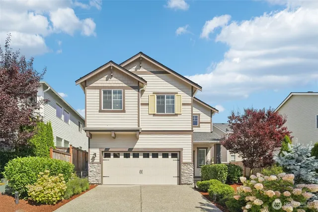 a view of a white house next to a yard with potted plants
