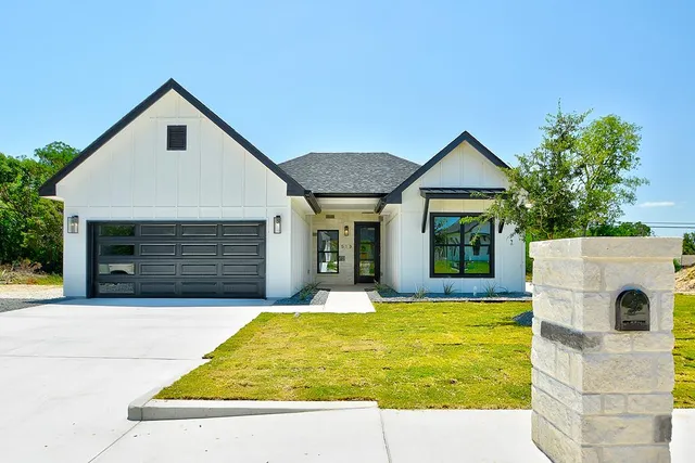 a white house with a large pool in front of it